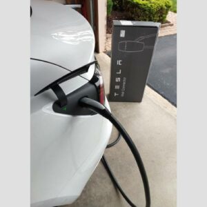 A white car is plugged into an electric vehicle charger.